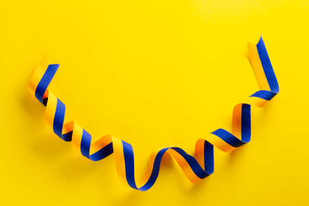 Ribbon with the flag of Ukraine on a yellow background in honor of Independence Day.の写真素材