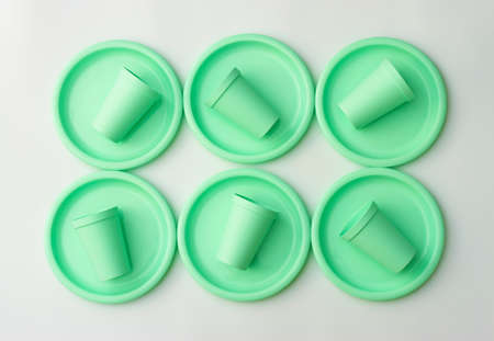 Plastic dishes in mint color on white background.