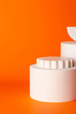 Composition of plaster decorations of different geometries on orange background.