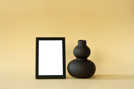 Frame with a blank space and a black vase on a delicate background.の写真素材