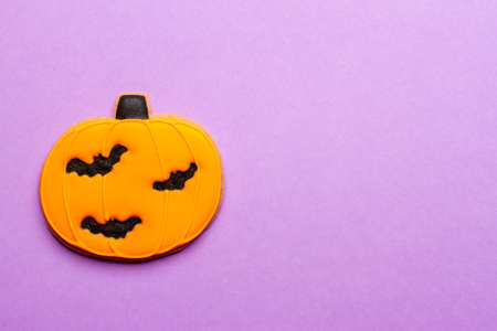 Homemade Halloween cookies, pumpkins on purple background