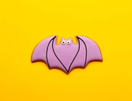 Homemade Halloween Bat Cookies on a Yellow Background.