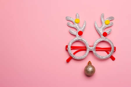 Christmas composition of glasses with reindeer antlers on a pink background.の写真素材