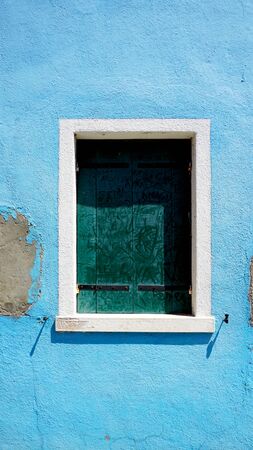 Window in Burano on blue decay wall building architecture, Venice, Italyの写真素材