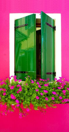 green wood paint Window in Burano with bright pink color wall building architecture, Venice, Italyの写真素材