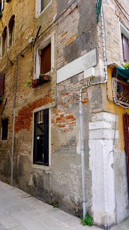 alley of old building with brick material in old town city Venice, Italyの写真素材