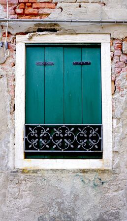 green Window on old brick wall building architecture, Venice, Italyの写真素材