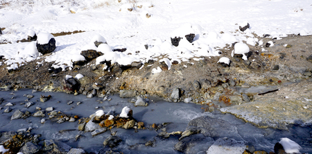 Closeup snow stone and stream in the mist Noboribetsu onsen snow winter national park in Jigokudani, Hokkaido, Japanの写真素材