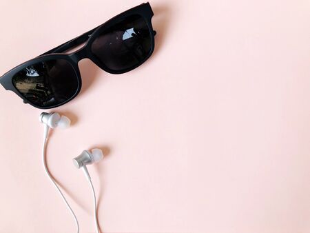 ear phone and sunglasses on pastel pink color background summerの写真素材