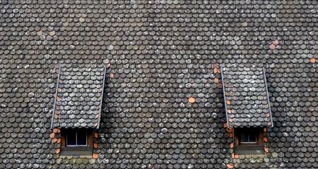 brown old ceramic tile roof top shingles middle ages with two window texture background in...