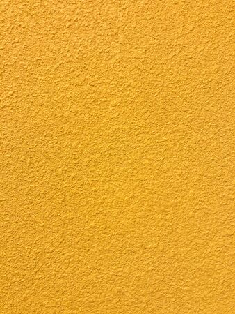 Golden yellow stone grain wall spray painted texture concrete background in retro style with copy spaceの写真素材