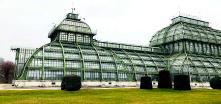 Elevation of botanical palm house architecture and grass field outdoors in Vienna, Austriaのeditorial素材
