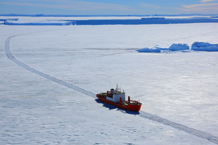 Cargo ship arrives in port for unloading on an ice floe. Antarctic.