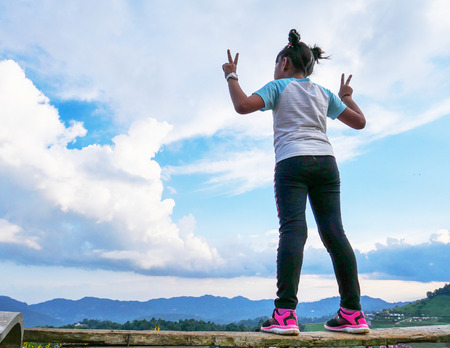 Back side of the girl hand up with sky backgroundの写真素材