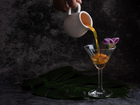 puring liquid into the glass to make a glass of cocktailsの写真素材