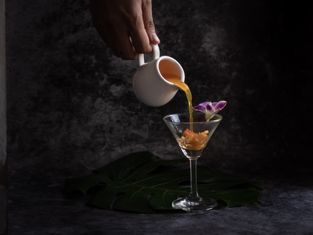 puring liquid into the glass to make a glass of cocktailsの写真素材