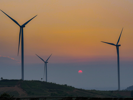 Wind turbine farm on the mountain at sunset time on orange light backgroundのeditorial素材