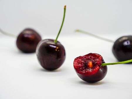 Isolated group of chrery fruit with 1 ate on white backgroundの写真素材