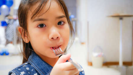 The pretty girl was holding fork in her hand and mouthの写真素材