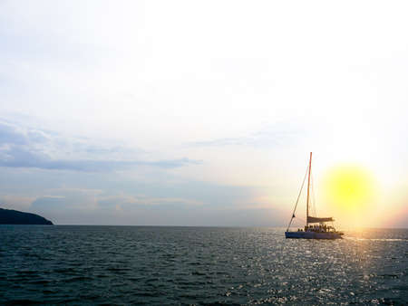 Boat traveling in the sea with yellow light backgroundの写真素材