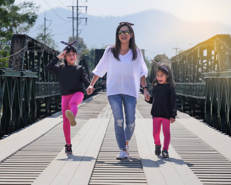 Mother with the childrens walking on the bridge with happy feelingの写真素材