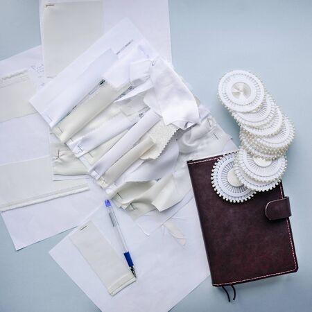 Sewing flat lay with samples of light fabrics, needles and fabrics. Factory production.の写真素材