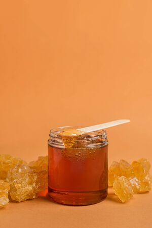 Container with paste for hair removal with sugar crystals on yellowの写真素材