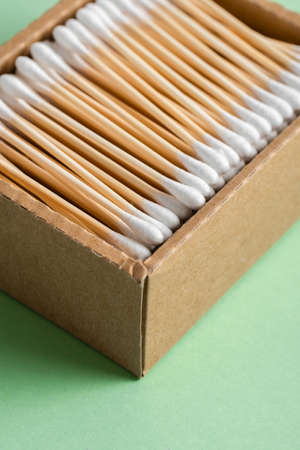 Eco natural bamboo ear sticks in a craft box on a green background. lifestyle concept. zero waste,...