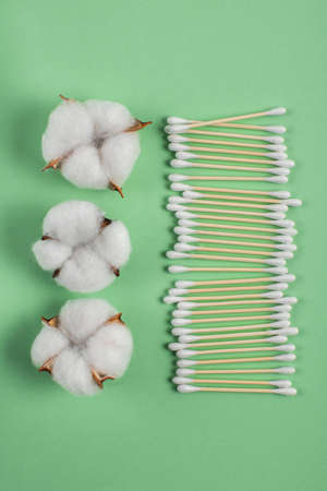 Flat lay with natural ear sticks and cotton bolls on a light green background. lifestyle concept. zero waste, plastic free items. stop plastic pollution. reuse, reduceの写真素材