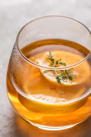 Hot tea in a glass with lemon and thyme close-up, side light. Autumn and winter traditional drinks.の写真素材