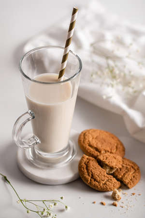 Glass of milk with homemade cookies on a white background. Breakfast and healthy food concept. white...