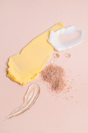 Composition of various cosmetic creams on a beige background. Skin care lotion serum texture sample. Closeup of a sample of a cosmetic product. Top viewの写真素材