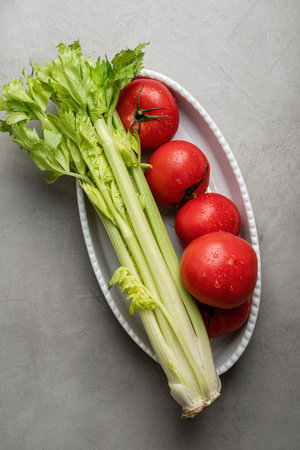 Fresh tomatoes and celery on a white plate. Healthy foodの写真素材