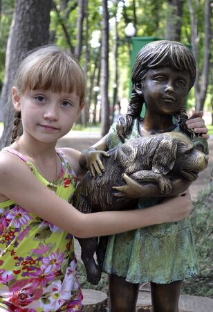 girl about sculpture in a city parkの写真素材