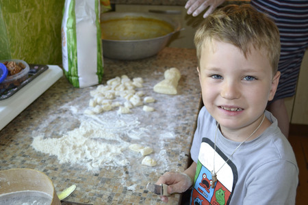 little boy helps to cook dumplingsの写真素材