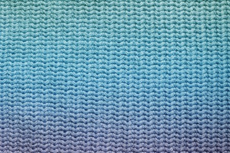Top view of a knitted fabric made of wool of purple blue aquamarine green gradient color