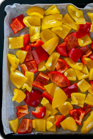 Mix red and yellow peppers cut into pieces and put into the pan の写真素材