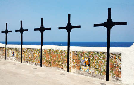 Wooden crosses painted black, are Placed one beside the other in the yard of a church. On the bottom of the horizon with the sea.の写真素材