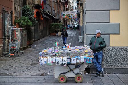 Naples, Italy - January 6, 2016: in a main street of the historic city center, a street vendor of phone accessories with his cart.のeditorial素材