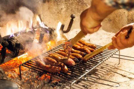 Sausages in a row on the grill are cooked on the grill of an open fire.の写真素材