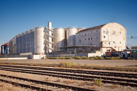Naples, Italy - August 10, 2016: In the commercial port city of silos for storage of goods and, in the foreground, the tracks of the inner rail used for cargo handling.のeditorial素材