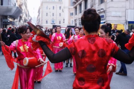 Rome, Italy - January 28, 2017: Chinese women in traditional dress, play and dance through the streets of the capital, during the procession celebrating the Chinese New Year in the year of the rooster.のeditorial素材