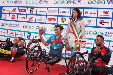 Rome, Italy - April 2, 2017: Alex Zanardi is the winner of the hand bike race of 23 ^ Rome Marathon. On stage together with the mayor Virginia Raggi during the award ceremony.のeditorial素材