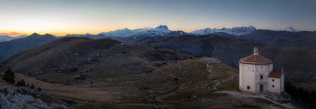 Church of Santa Maria della Pieta, overview and in the background the great horn of the Gran Sasso of Italy (Calascio AQ).の写真素材