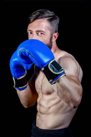 Boxer portrait in half bust, artificial lighting, black background.の写真素材