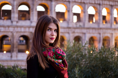 Russian girl posing in front of the Colosseum in Rome. The girl is wearing a typical Russian...