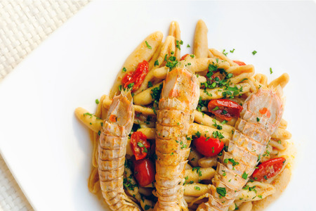 Ready dish of "pici", typical Italian fresh pasta, based on sea cicada, tomato, oil and parsley. Sea food, ready to eat.の写真素材