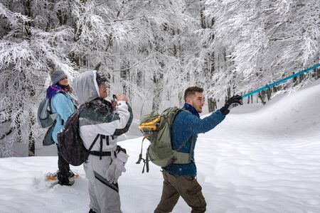 Subiaco, Italy - February 25, 2018: In the middle of winter, a group of people take an excursion on the snow-covered mountain, with snowshoes on their feet.のeditorial素材
