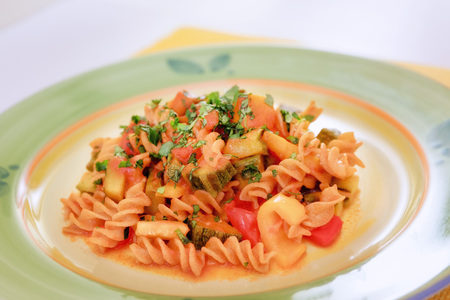 Fusilli dressed with tomato sauce, courgettes, aubergines and peppers. Pasta with vegetables, ready to eat.の写真素材