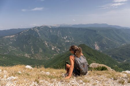 Subiaco RM, Italy - 07 July 2019: woman hiker admires the landscape on the horizon, from the top of the mountain.のeditorial素材